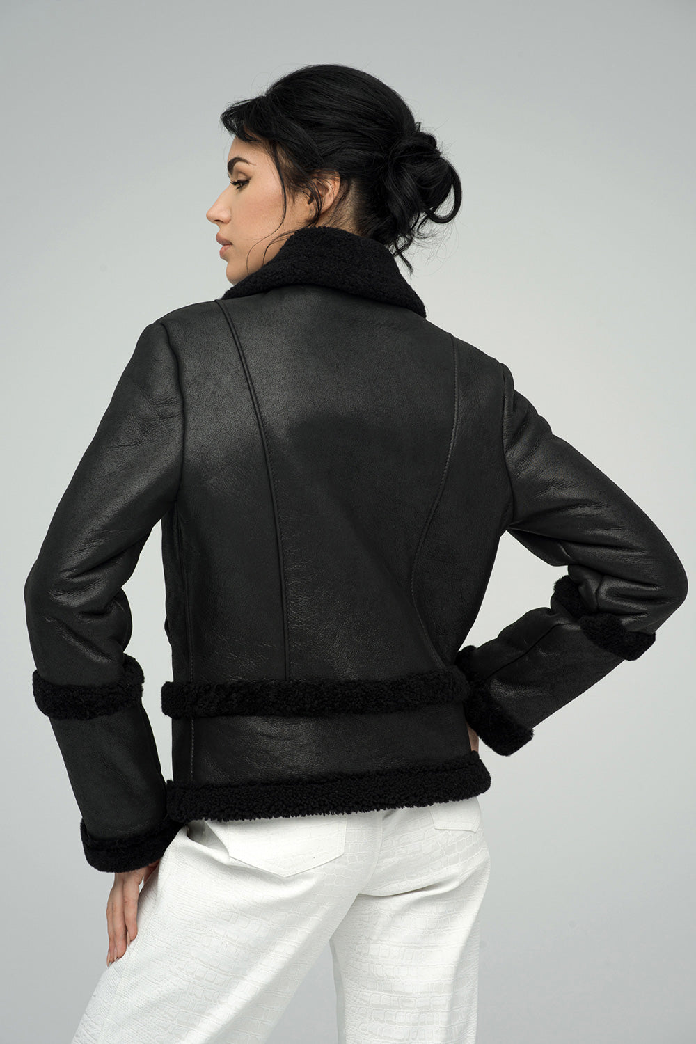 Black Merino Shearling Leather Jacket featuring a stylish design with a soft shearling collar and cuffs, shown from the back.