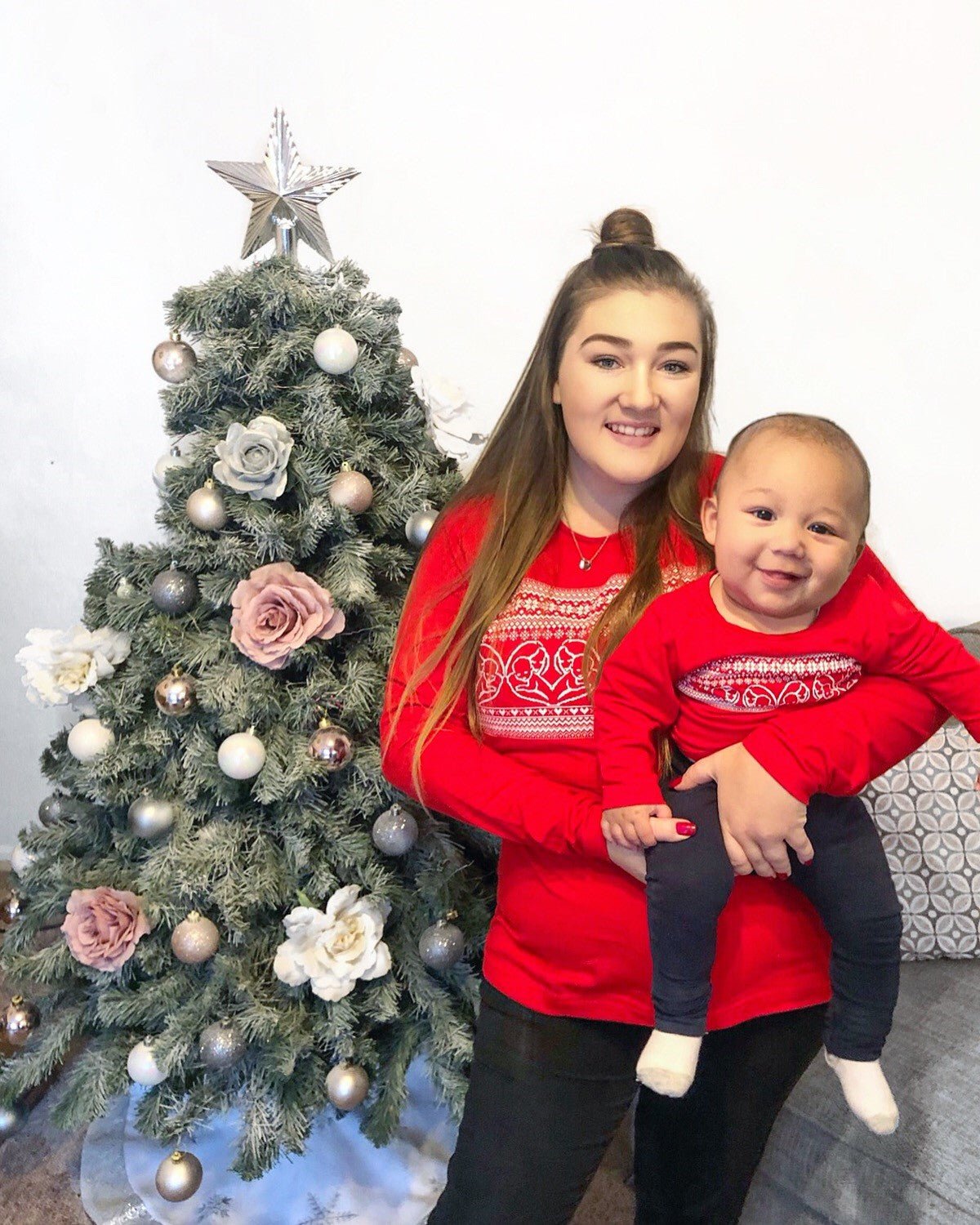 Red Heart Breastfeeding Top featuring a festive design, worn by a woman holding a smiling baby in front of a decorated Christ