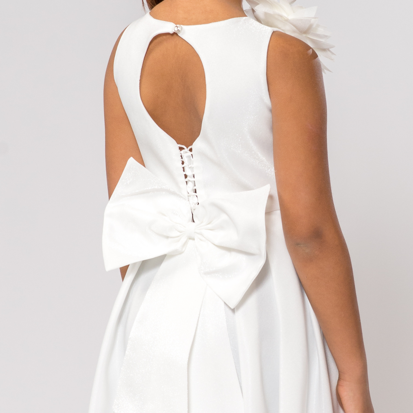 White A-Line dress with a keyhole back and large bow detail at the waist, featuring a shimmering fabric finish.