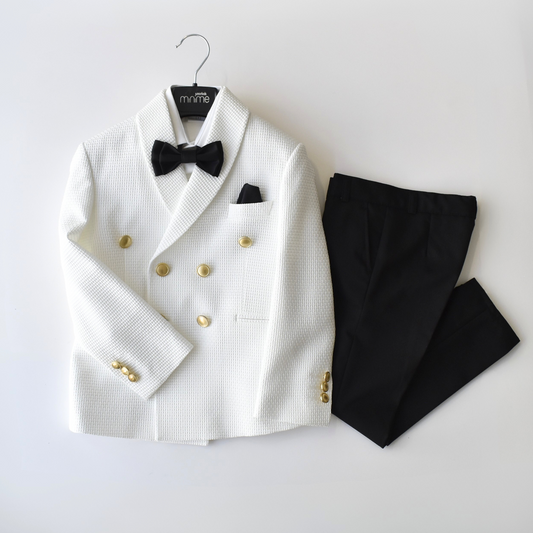 White double-breasted boys suit with gold buttons, black bow tie, and black pants, displayed on a hanger.