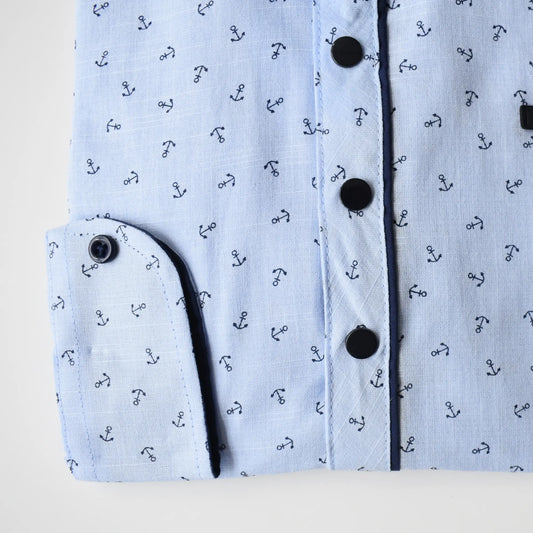 Light blue Anchor Boys Cotton Shirt featuring a nautical anchor pattern and black buttons. Folded sleeve detail visible.