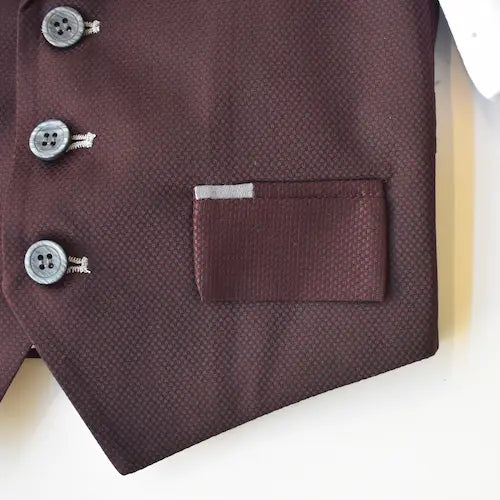 Dapper David Formal Vest Set in burgundy with button details and a pocket. Elegant fabric texture and tailored design.