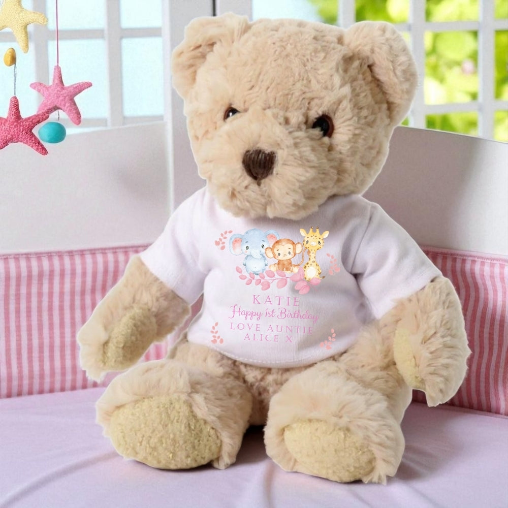 Personalised luxury teddy bear wearing a white birthday t-shirt with colorful animal graphics and the name "Katie."