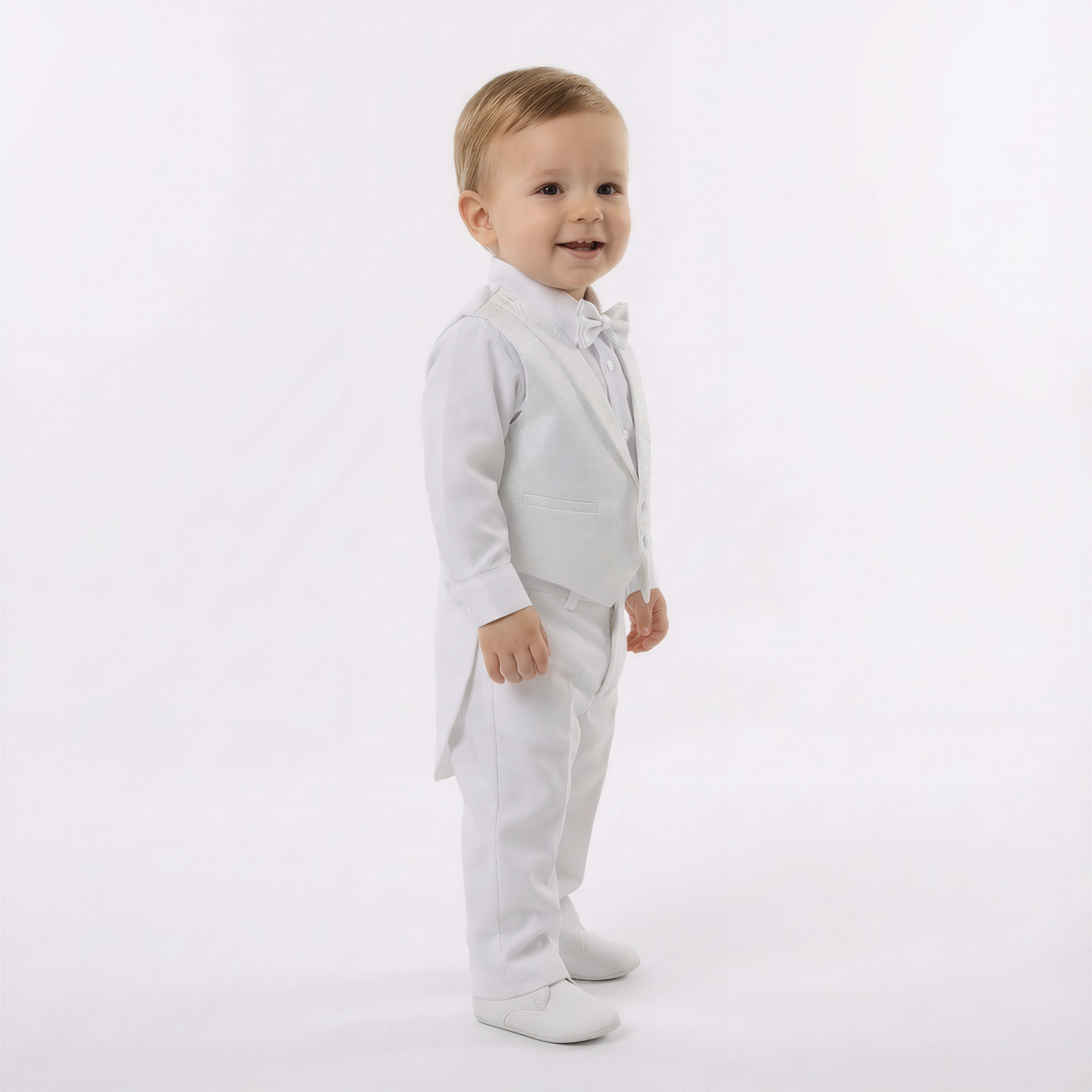 Archie's Penguin Tail Vest Set features a young boy in a white vest, bow tie, and pants, with matching shoes.