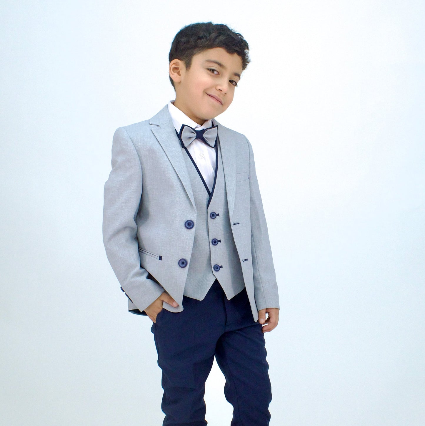 Stylish gray formal suit for boys, featuring a double-breasted jacket, vest, and bow tie, paired with navy trousers.