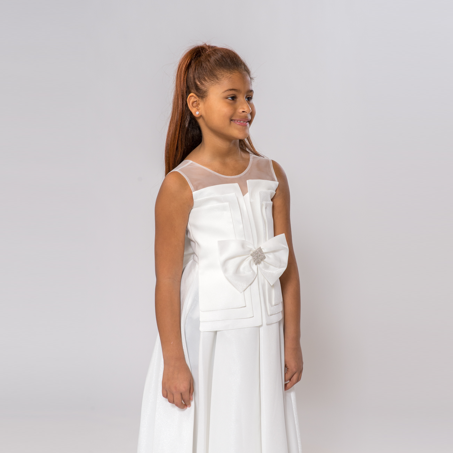 White Splendid Charm A-Line Dress featuring a sheer neckline and a large bow detail on the waist, modeled by a girl.