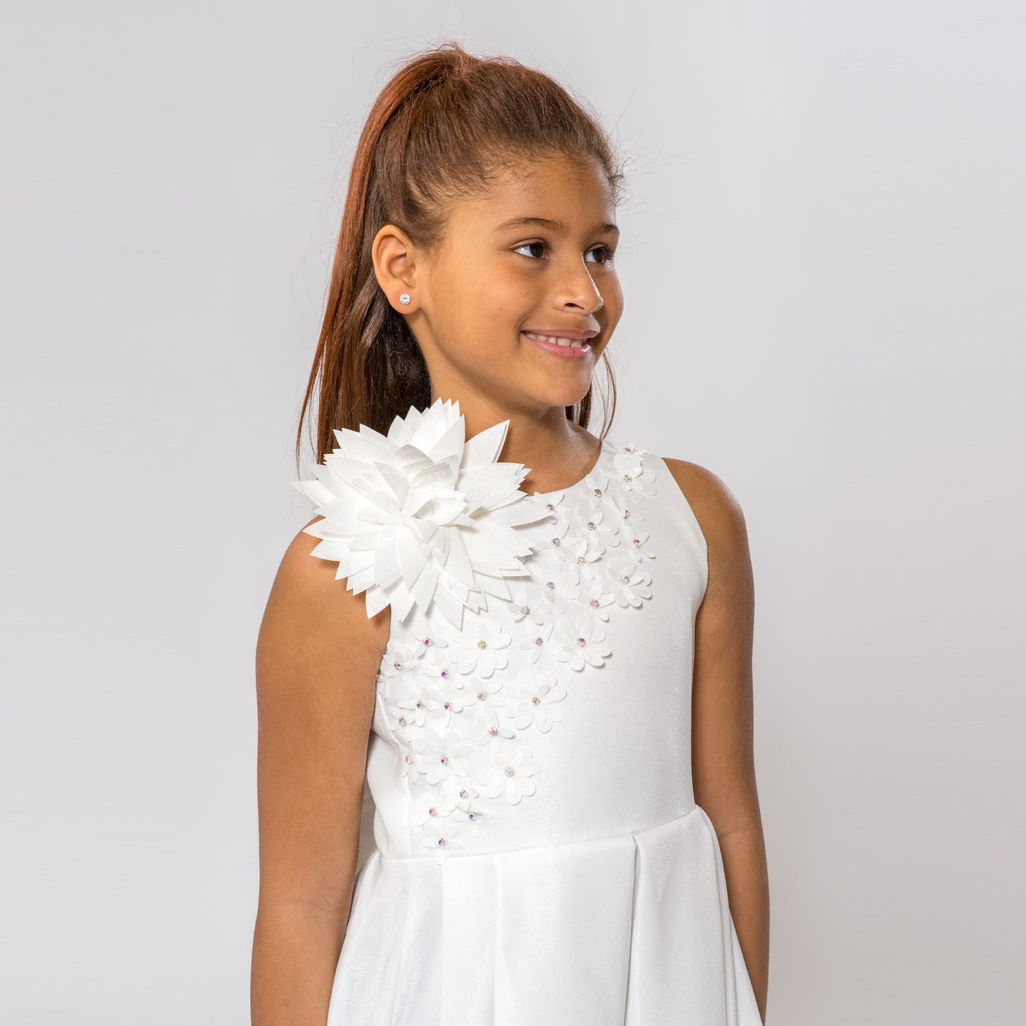 A-line dress for girls in white with floral embellishments and a large flower accent on one shoulder.
