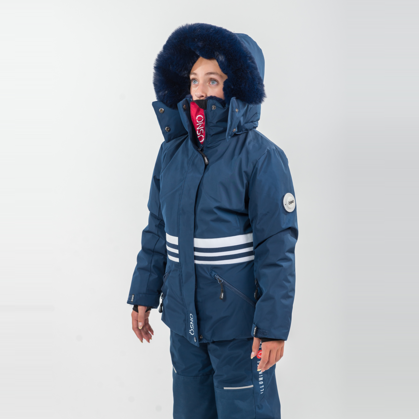 Karina's Luxury Snowsuit features a navy jacket with a fur-lined hood and matching snowpants, designed for warmth and style.