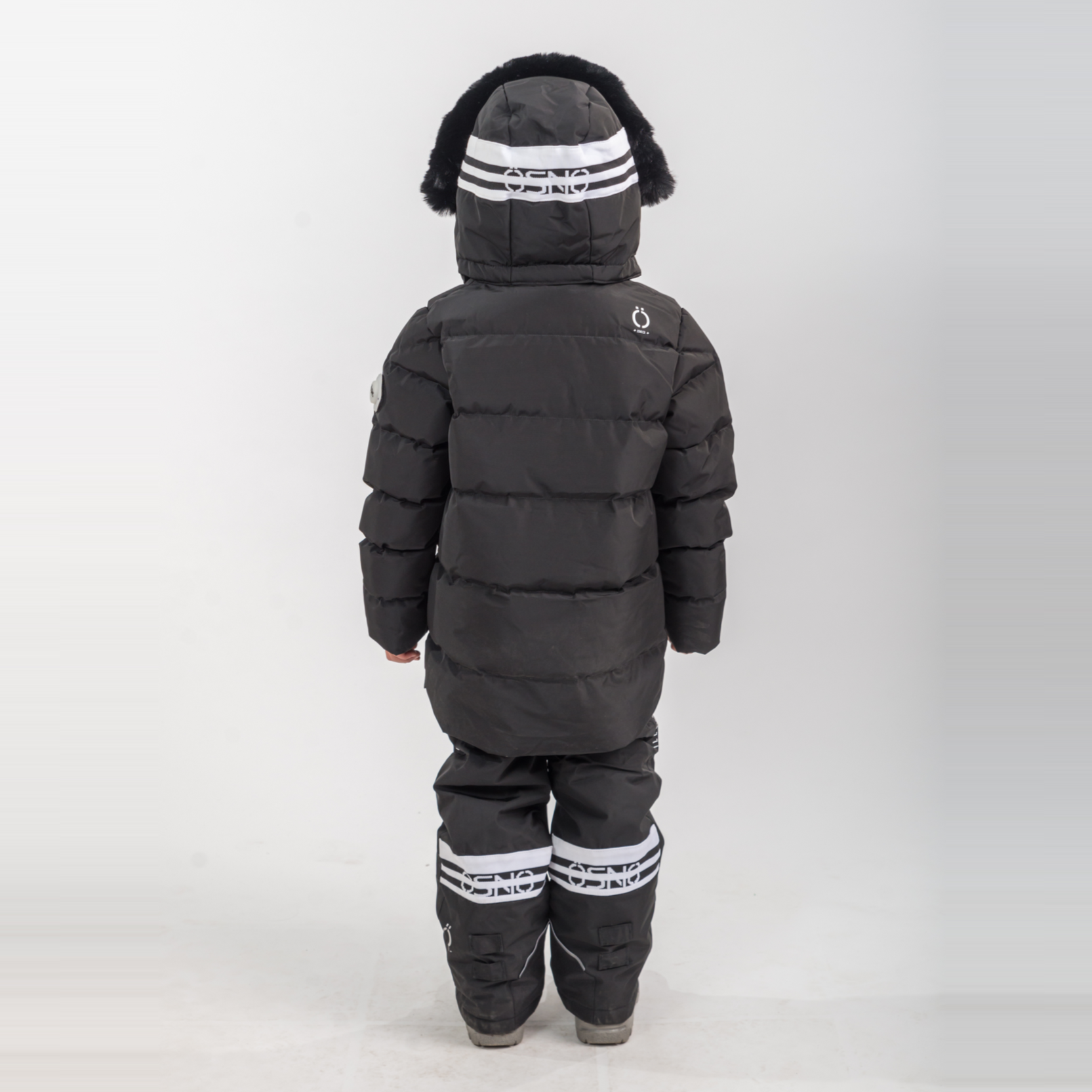 Rafa's Luxury Snowsuit features a black puffy jacket with a fur-lined hood and matching snowpants, designed for warmth and st