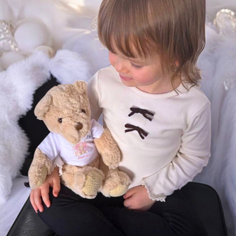 Personalised Pink Flower Heart Name Gift Hamper featuring a child holding a teddy bear in a custom vest.