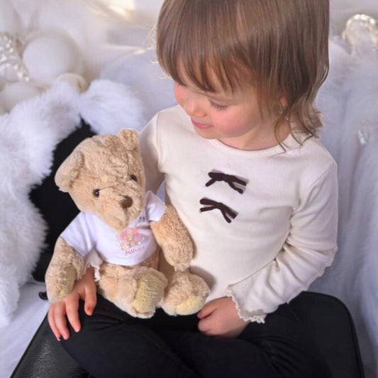Personalised Pink Flower Heart Name Gift Hamper featuring a child holding a teddy bear in a custom vest.