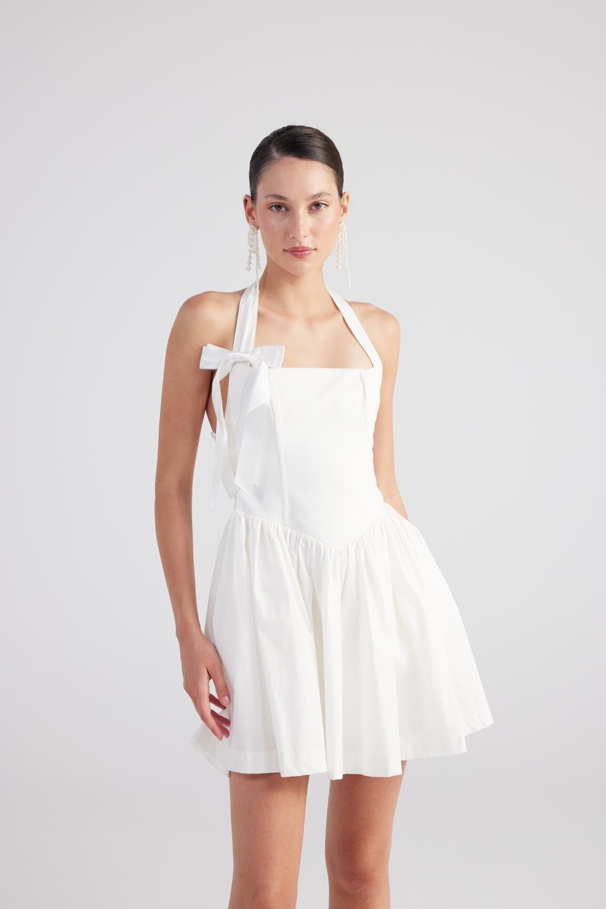 Teresa White Pleated Skirt Mini Dress featuring a halter neck, bow detail, and a flared skirt design.