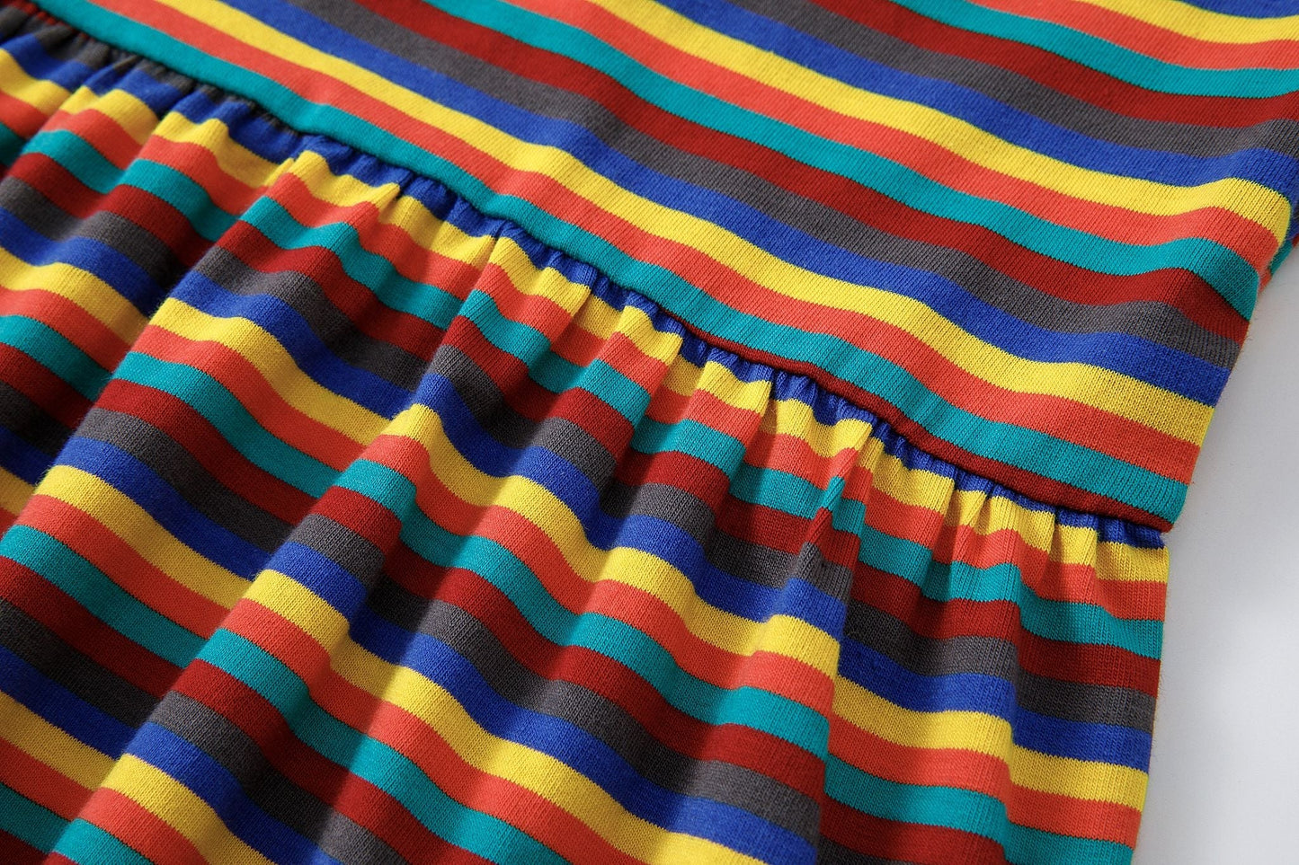 Colorful striped fabric of the Hazel Rainbow Super Soft Cotton Baby Child Dress featuring red, yellow, blue, and brown hues.