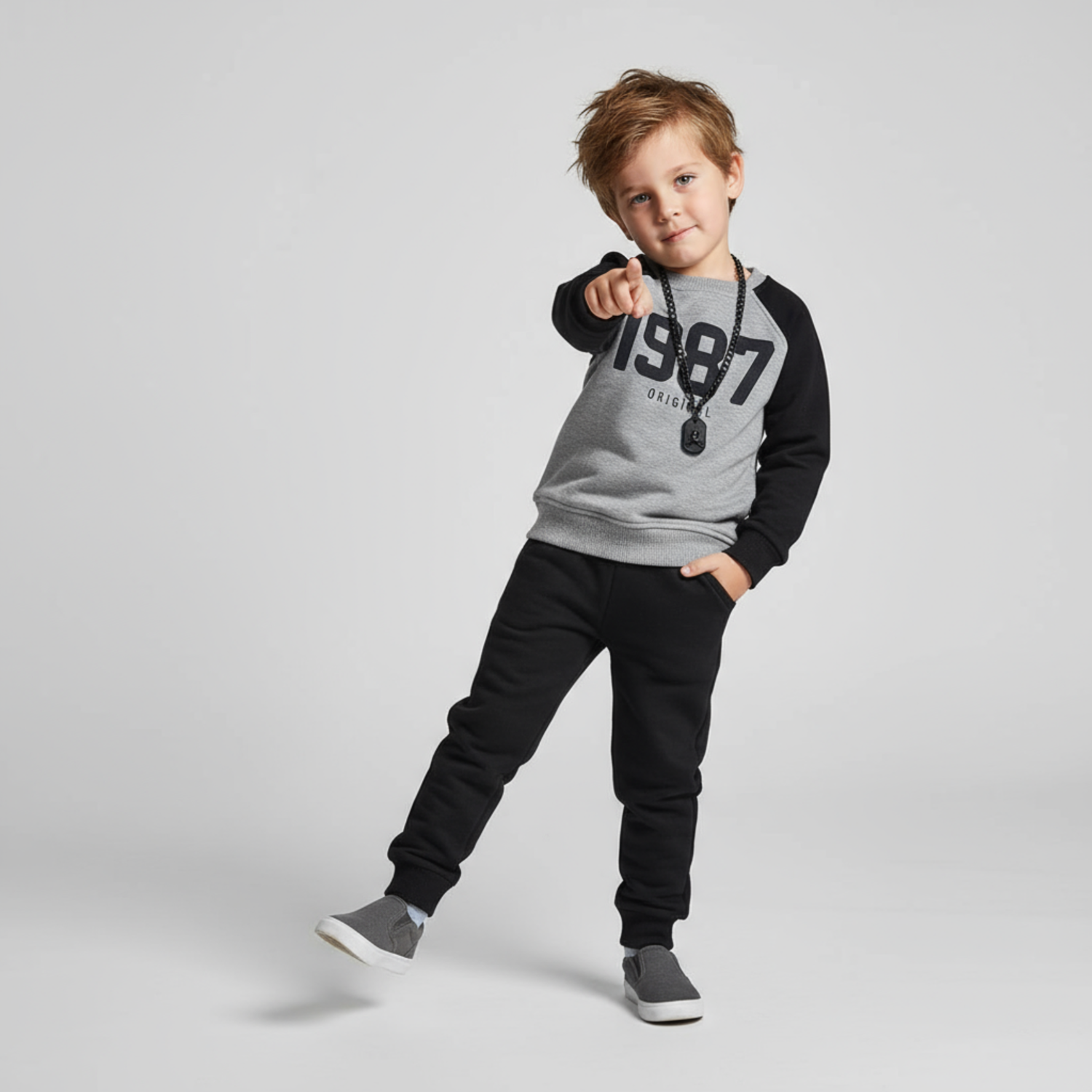 Boys joggers set featuring a gray and black long-sleeve top with "1987" print and black joggers, styled with a necklace.