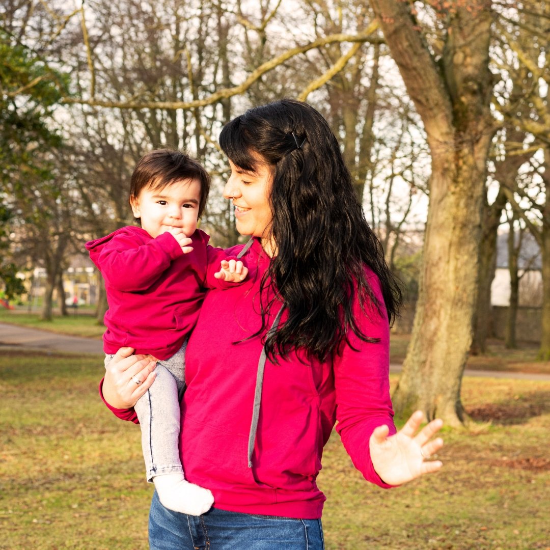 MilkyMoon Kid Hoodie in vibrant red worn by a mother and her child outdoors, surrounded by trees.